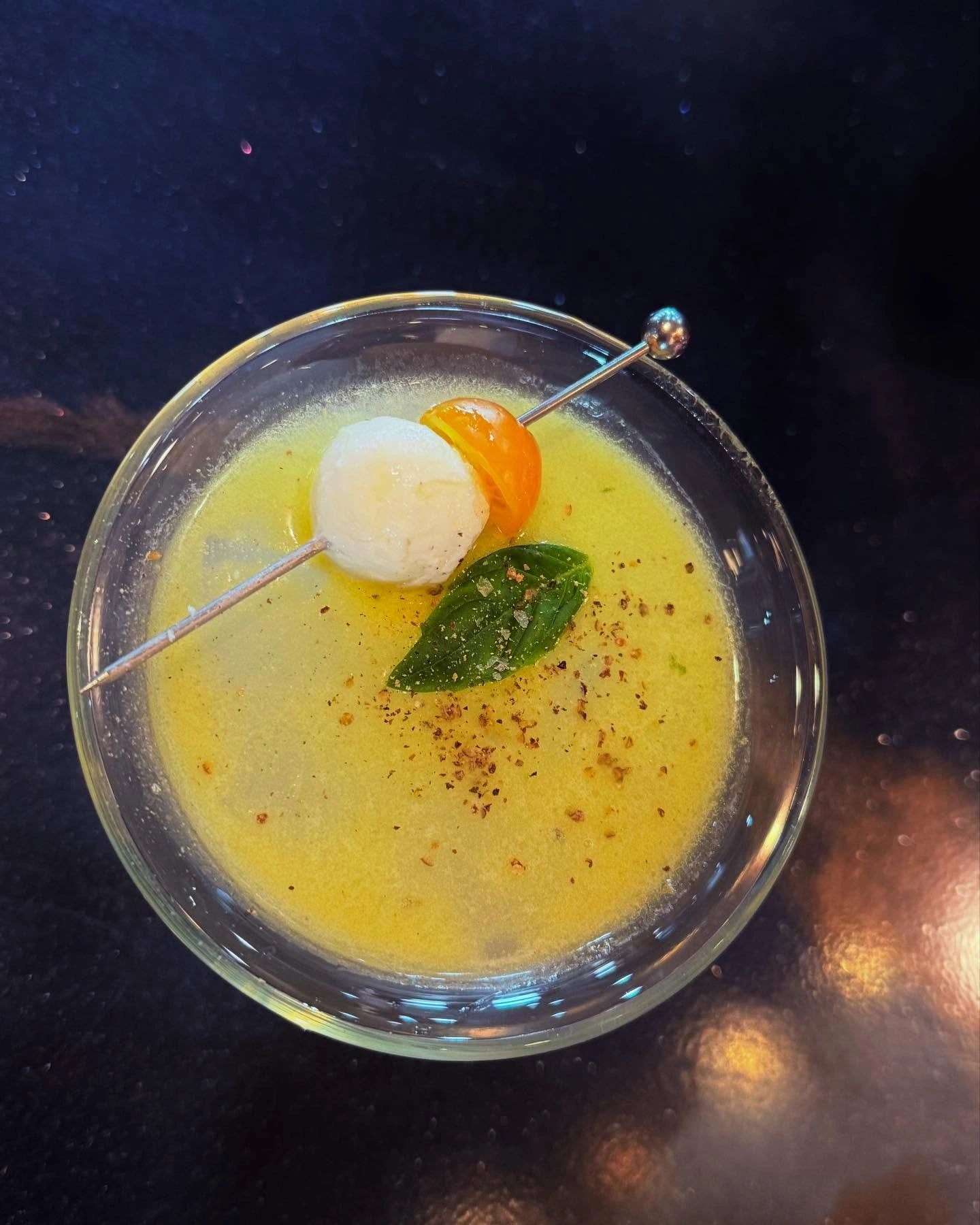 Yellow cocktail with lychee garnish